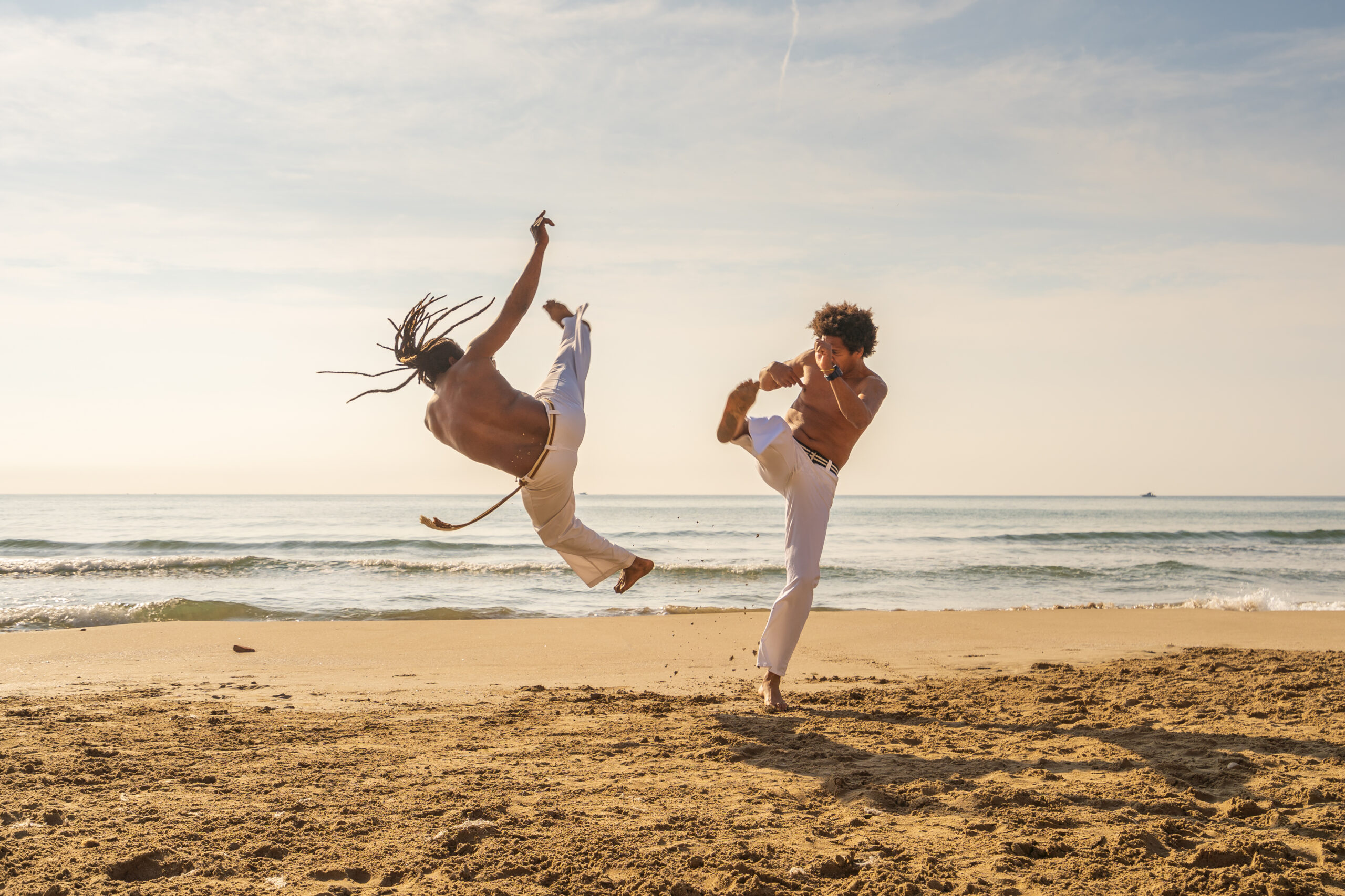 Deux capoeristes sur la plage en train de jouer la roda de capoeira